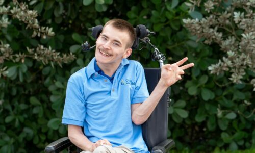 Ben in his chair waving and smiling
